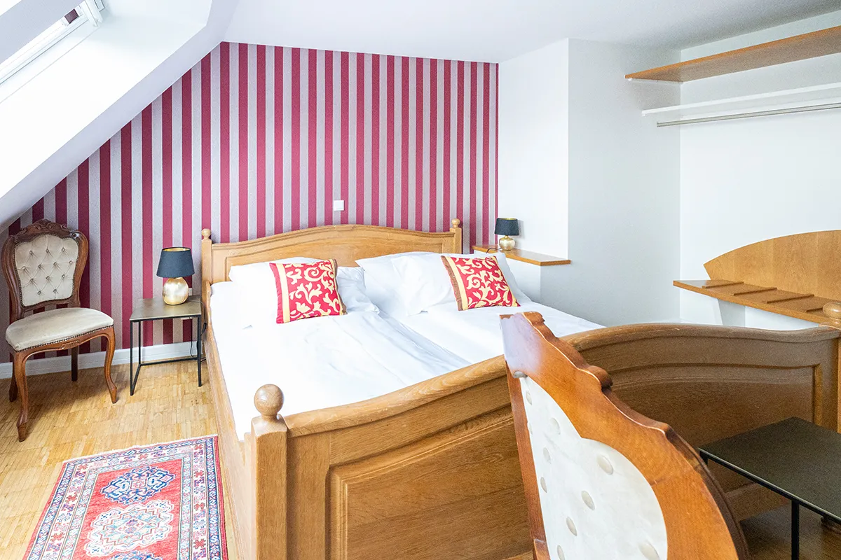 Dachzimmer mit beerenfarbener Streifentapete