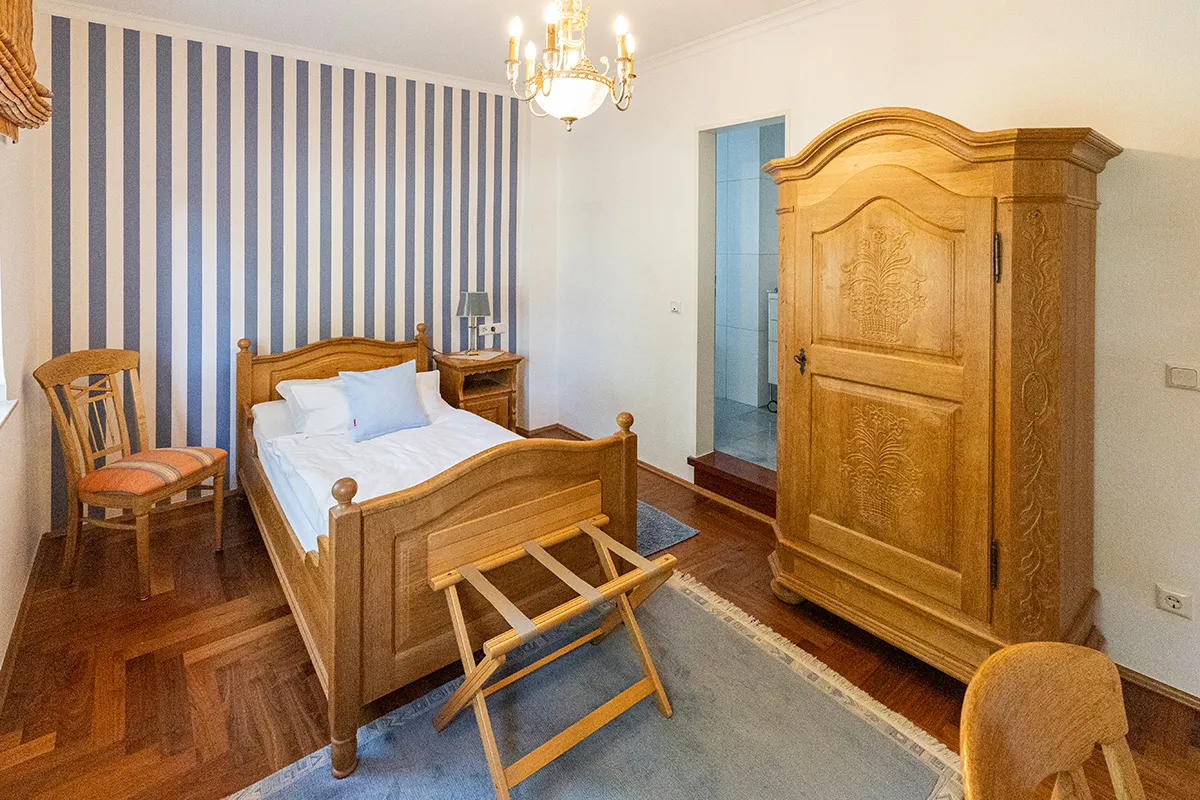 Doppelzimmer mit blau-weiß gestreifter Wand