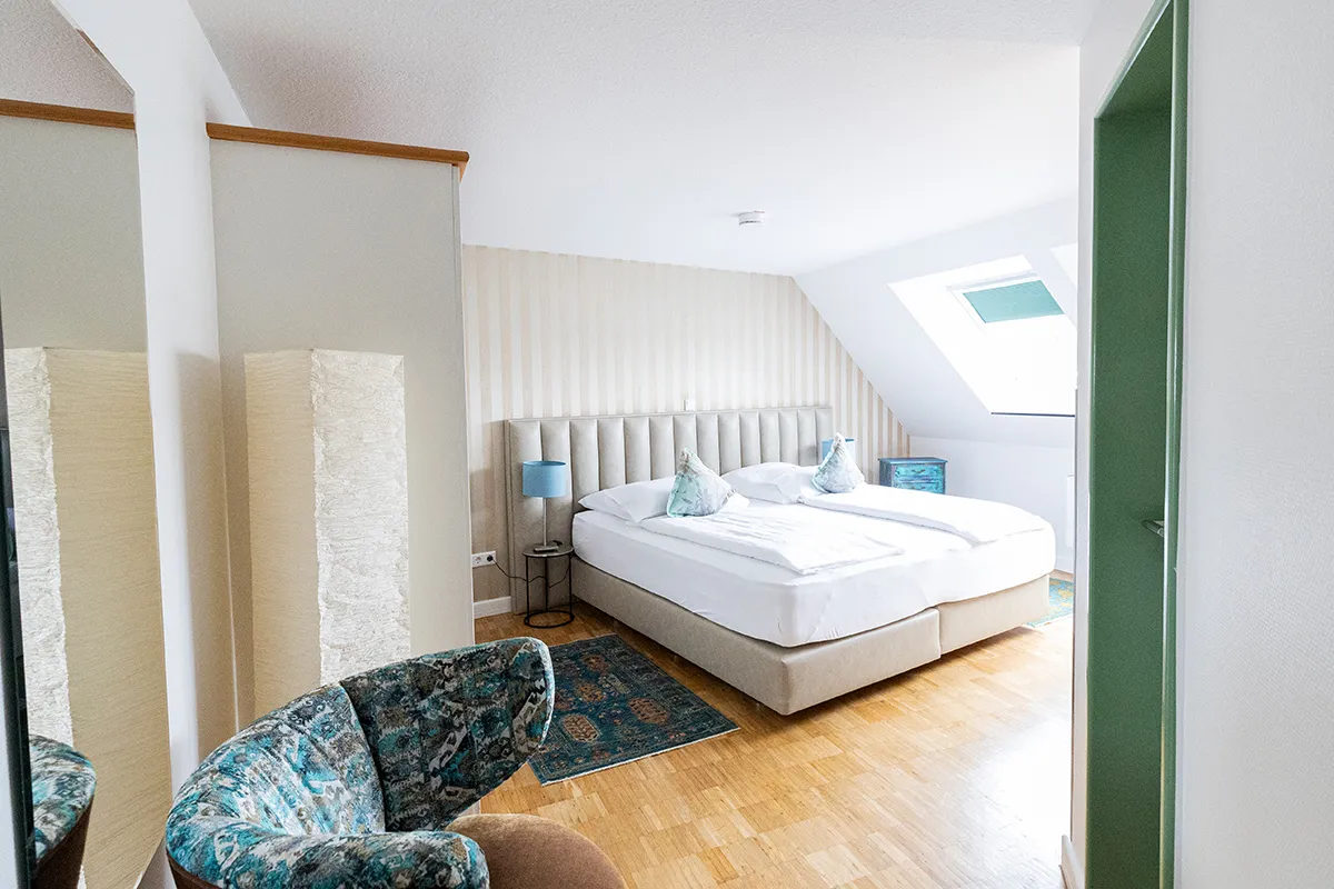 Dachzimmer mit Boxspringbett in Creme