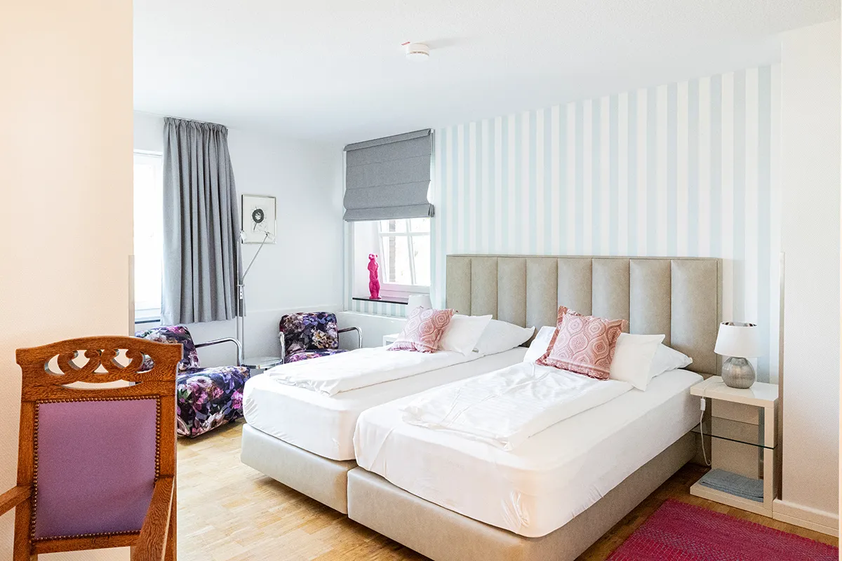 Doppelzimmer mit hellblauer Streifenwand