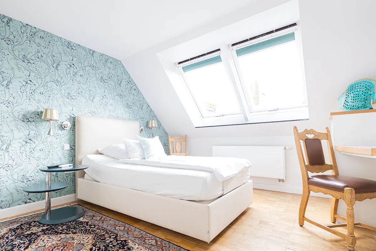 Dachzimmer mit mintgrüner Tapete und Dachfenstern