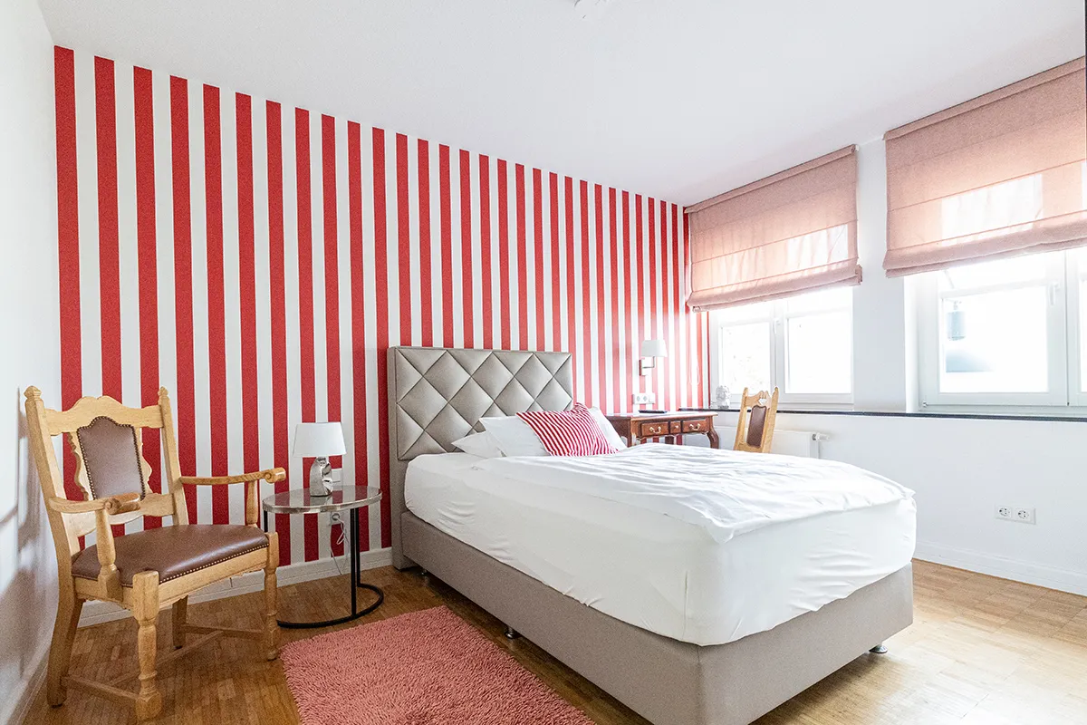 Doppelzimmer mit rot-weiß gestreifter Wand